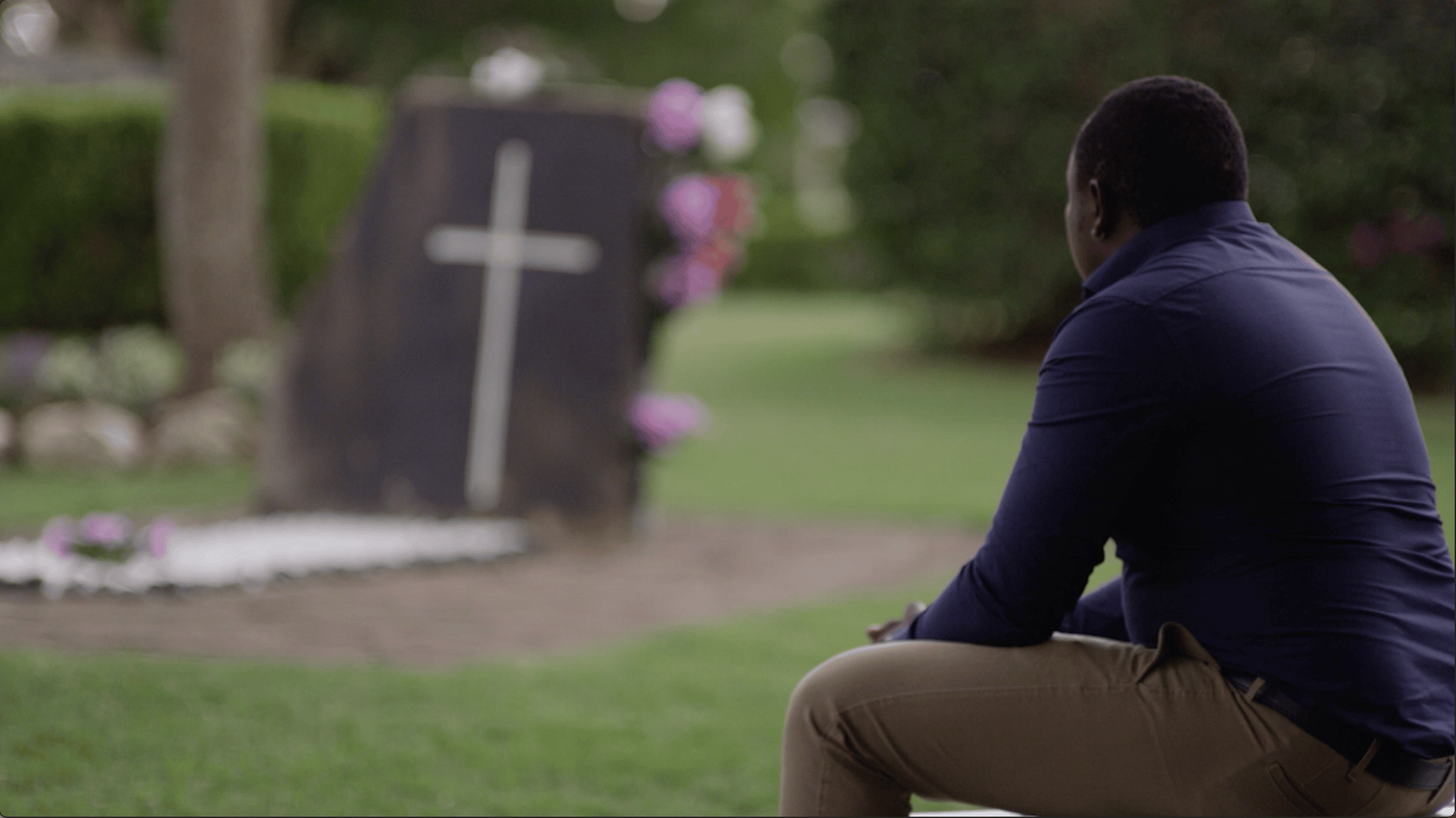 man looking at a grave