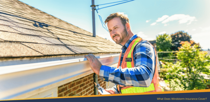 Man checking the roof's gutter for windstorm damages