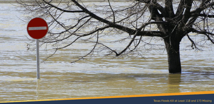 Flooded area with a no-entry traffic sign and a partially submerged tree, illustrating the impact of severe flooding in Texas.