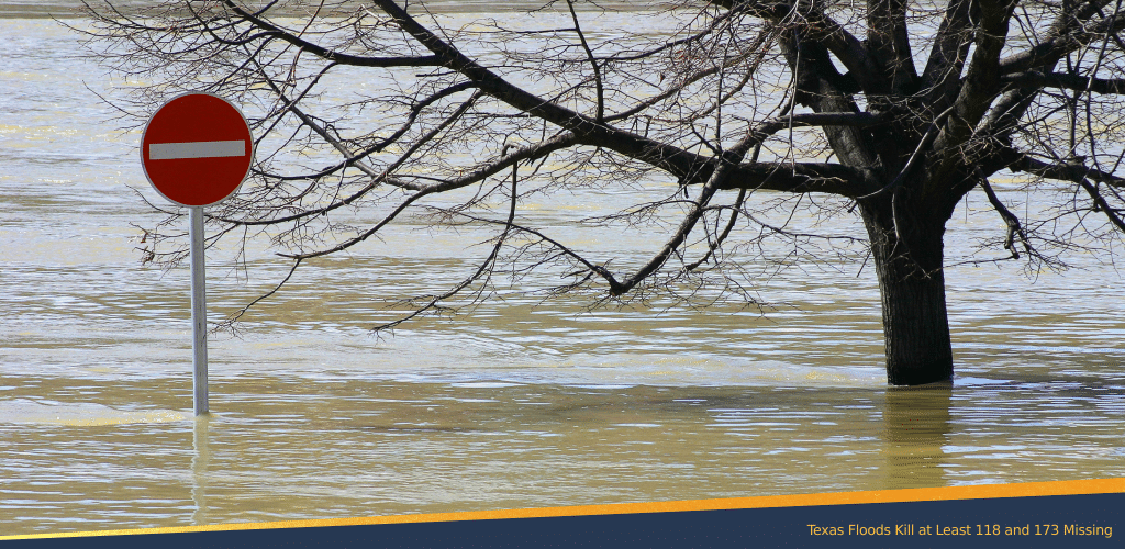 Flooded area with a no-entry traffic sign and a partially submerged tree, illustrating the impact of severe flooding in Texas.