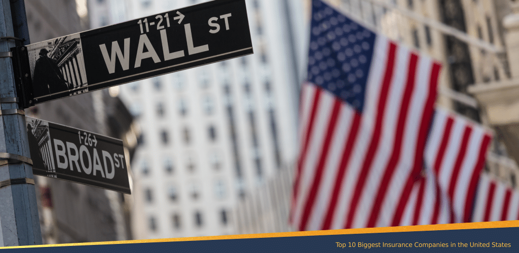 Wall Street and Broad Street signs in New York City with blurred American flags in the background, symbolizing the U.S. financial and insurance industry.